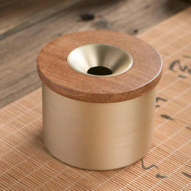 Brass ashtray with wooden lid showing central aperture design