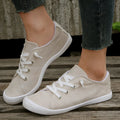 Women's creamy white fabric casual sneakers with rubber soles showing low-top design