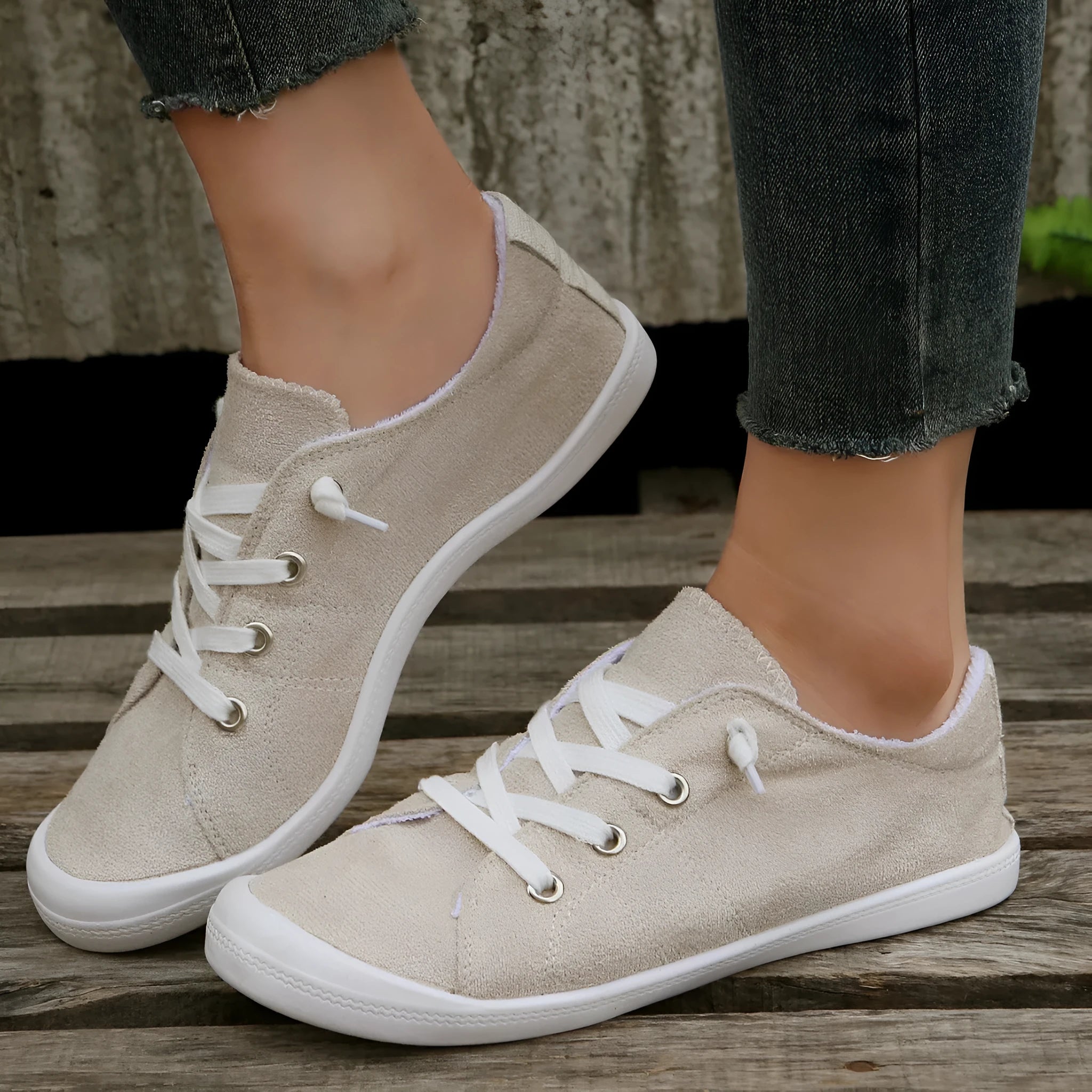 Women's creamy white fabric casual sneakers with rubber soles showing low-top design