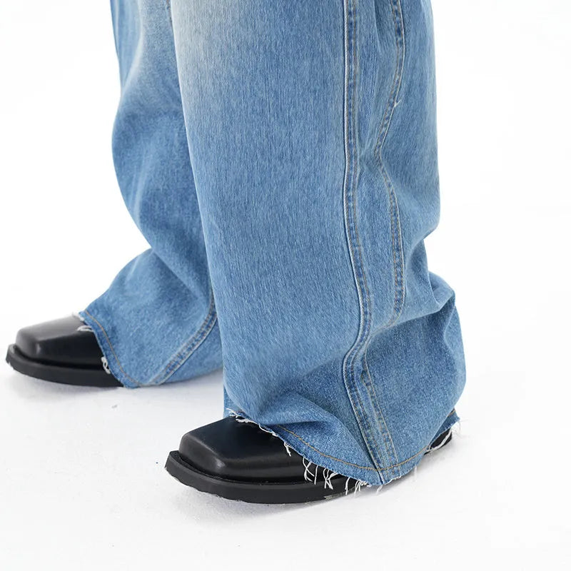 Light blue wide leg machete jeans with vintage washed denim finish, zip-fly closure, cut wash effect