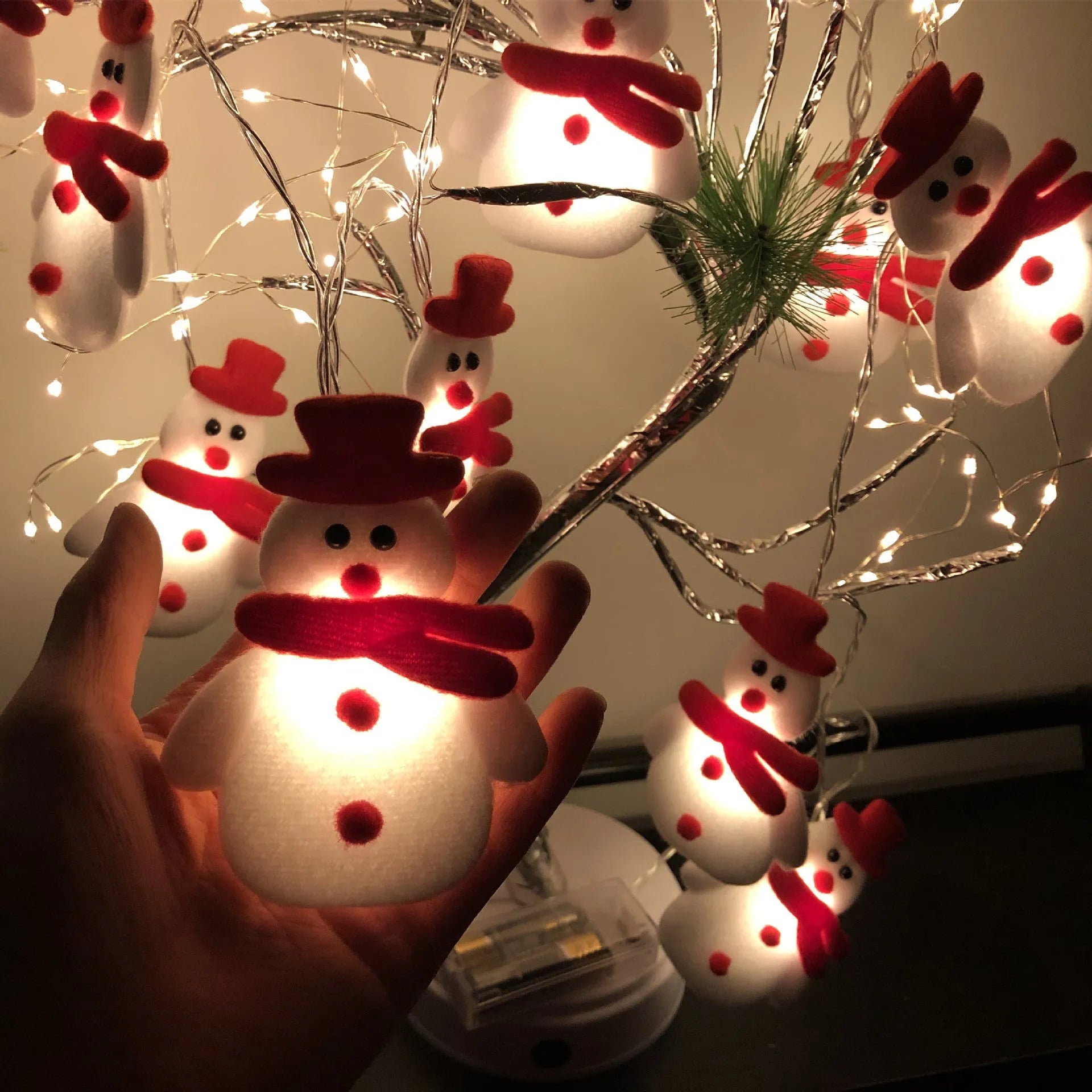 Christmas LED string lights with snowman figures, warm white glow, 1.65m length, battery powered, on a wooden mantelpiece
