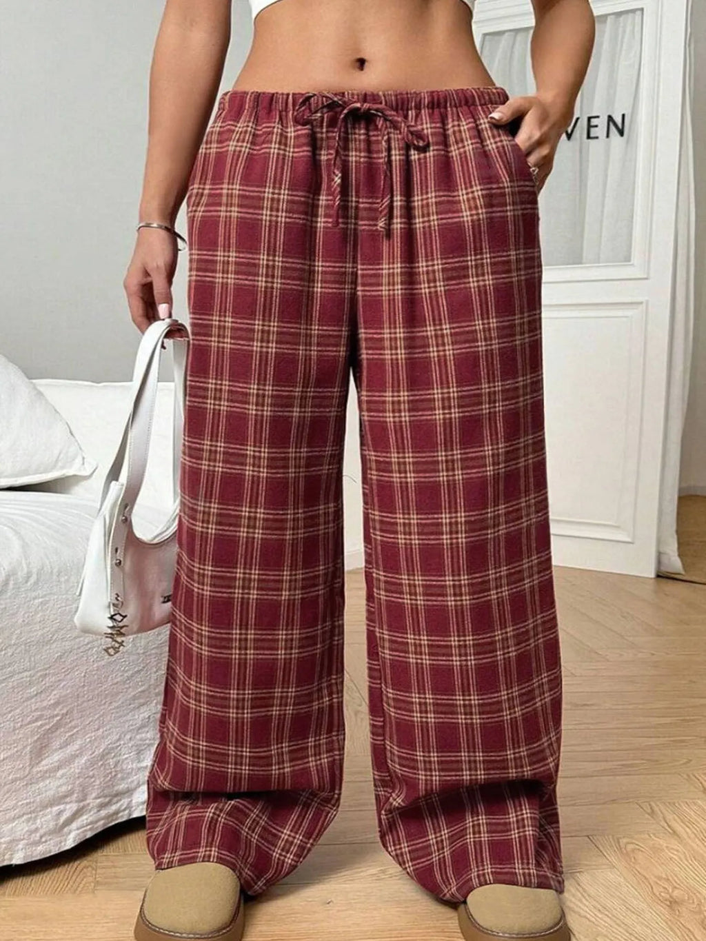 Women's red casual loose trousers with drawstring waist and plaid patch pockets laid flat.