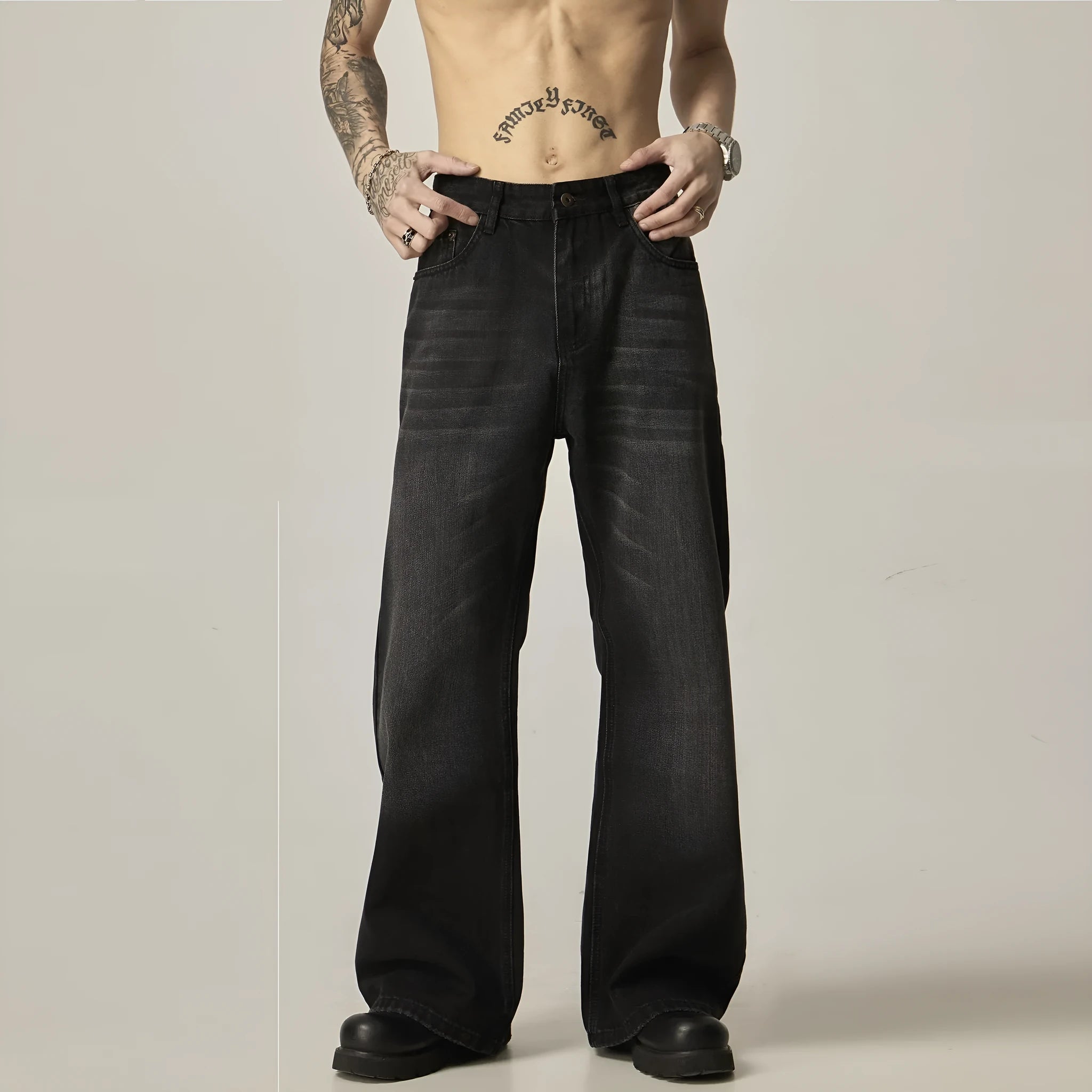 Man's black loose-fit straight-leg jeans with a retro style on a plain background.