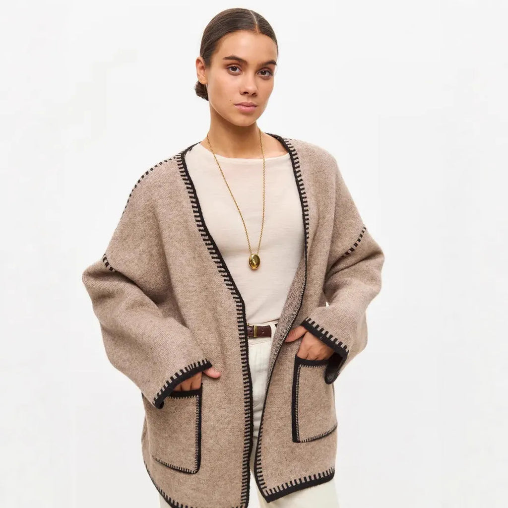 Loose knit camel coloured cardigan sweater with long sleeves on a hanger