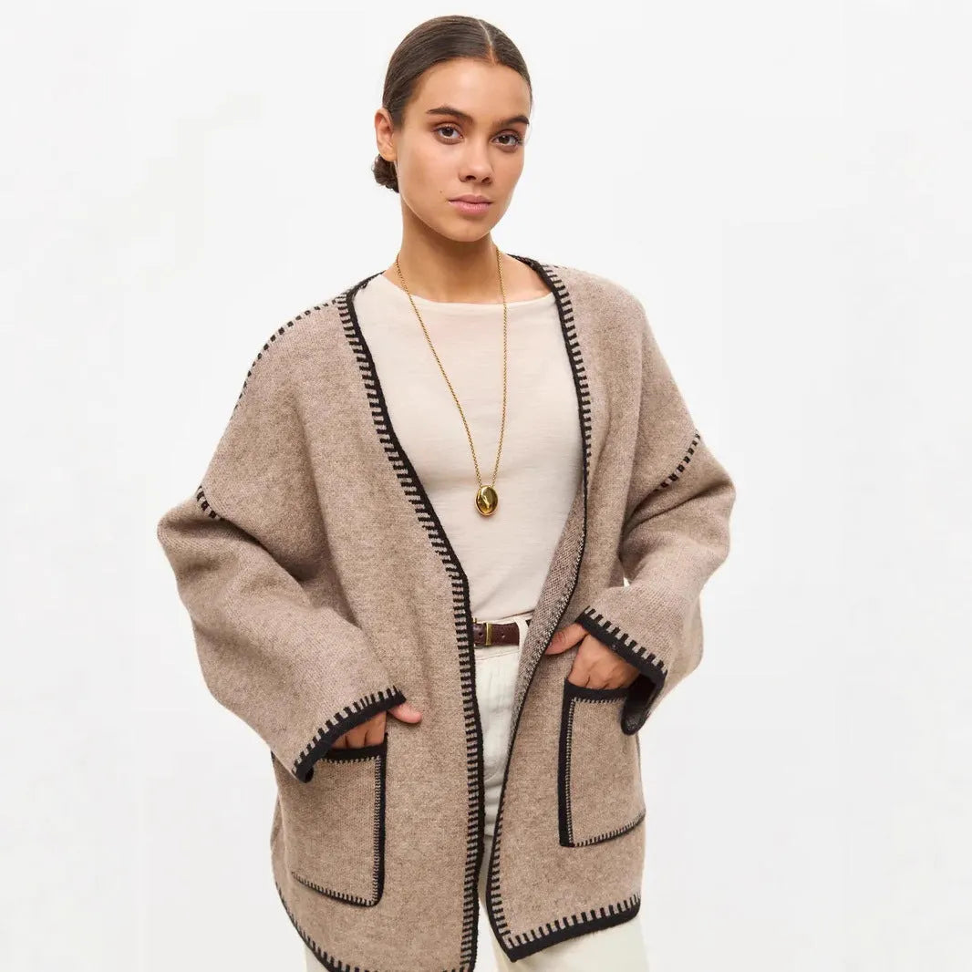 Loose knit camel coloured cardigan sweater with long sleeves on a hanger