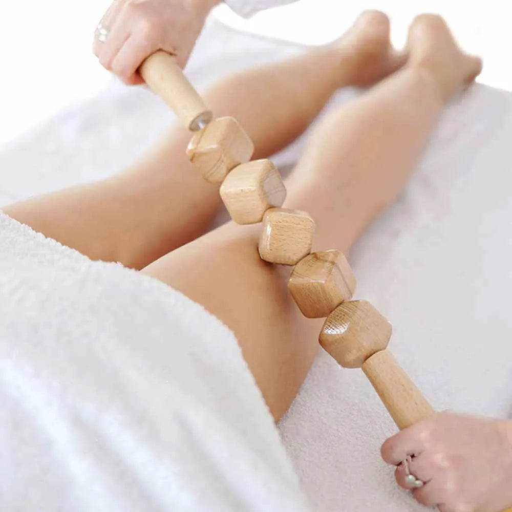 Set of three birch wood anti-cellulite massage hand rollers on a white background