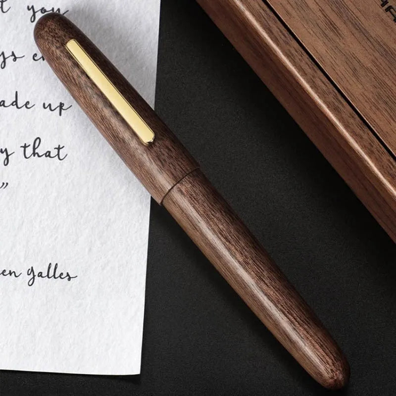 Wooden fountain pen with a rotating cap shown alongside nib options on a desk.