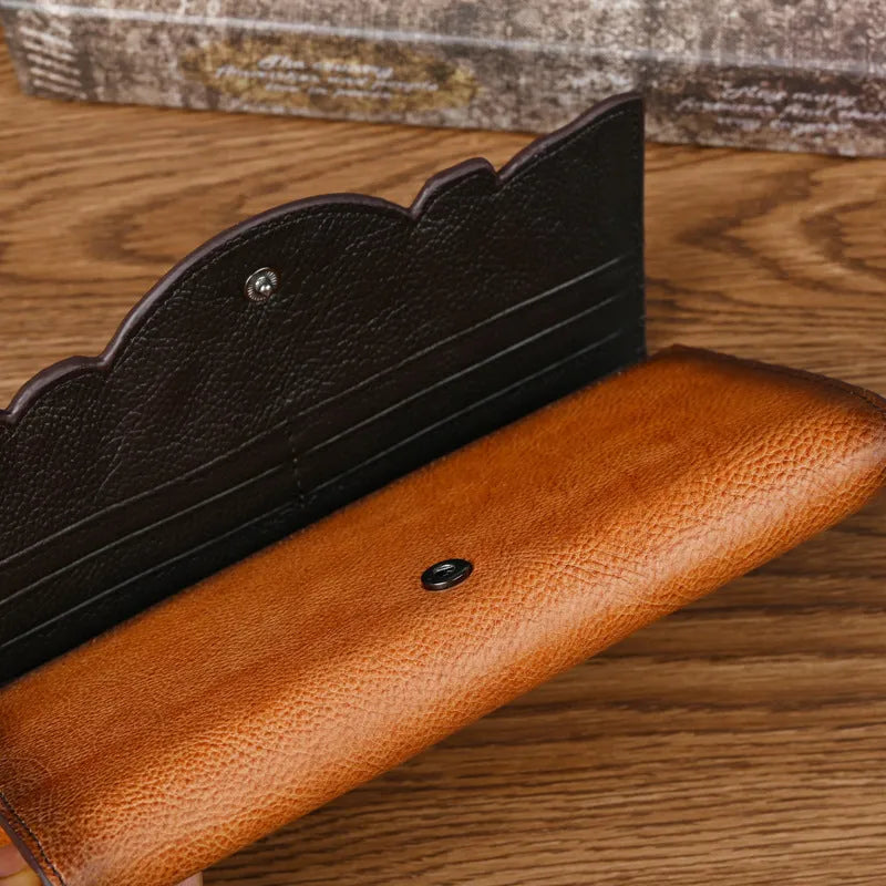 Brown genuine leather tri-fold wallet with embossed floral pattern showing interior compartments