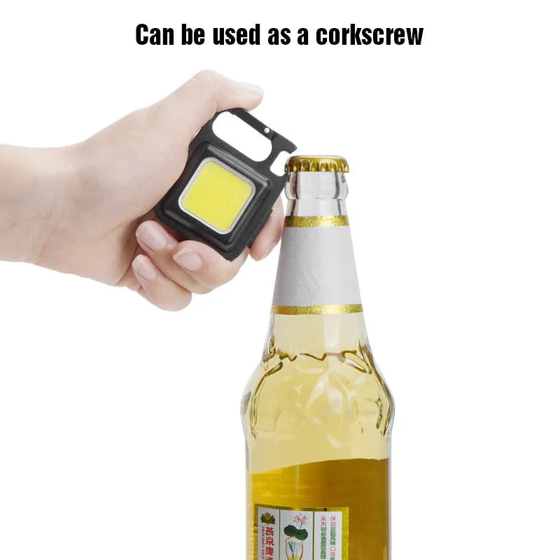 Black aluminium alloy COB keychain light with magnetic base, foldable handle, and key ring, 6x4.2cm