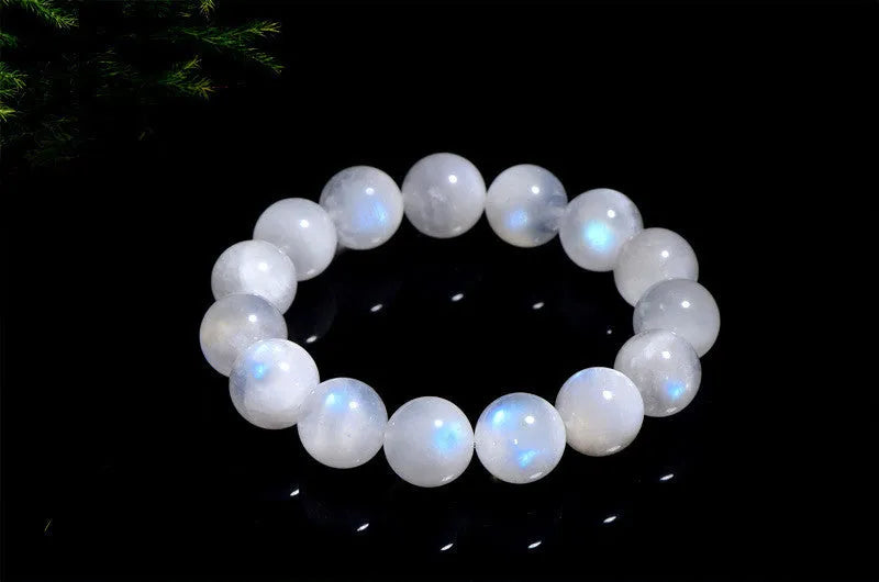 White polished moonstone bead bracelet with blue moonlight sheen, showing round geometric beads.