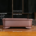 Rectangular antique purple sand bonsai pot on floor, showing Old Segment Mud textured finish.
