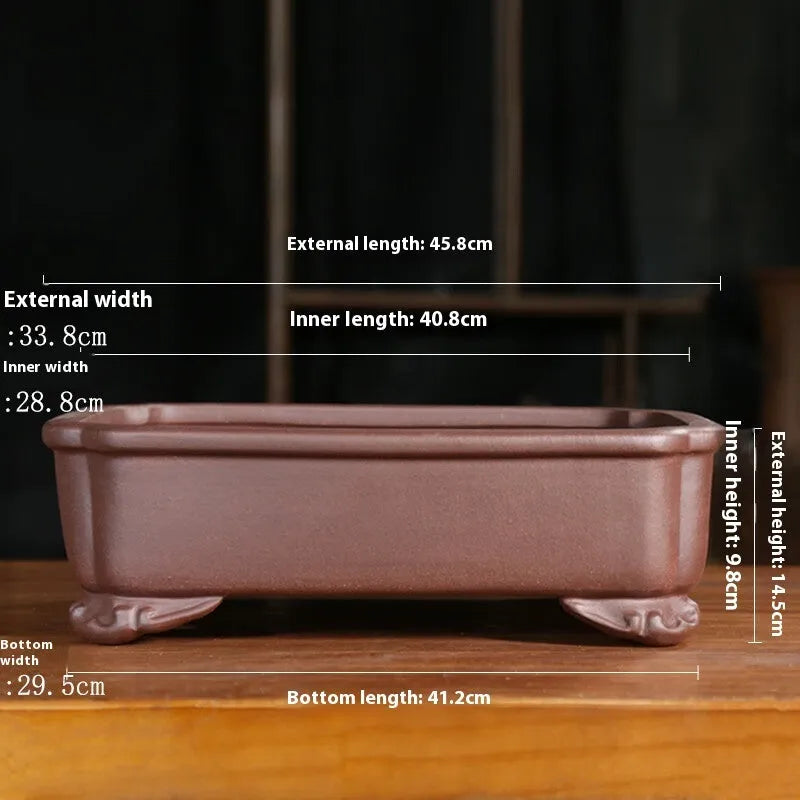 Rectangular antique purple sand bonsai pot on floor, showing Old Segment Mud textured finish.