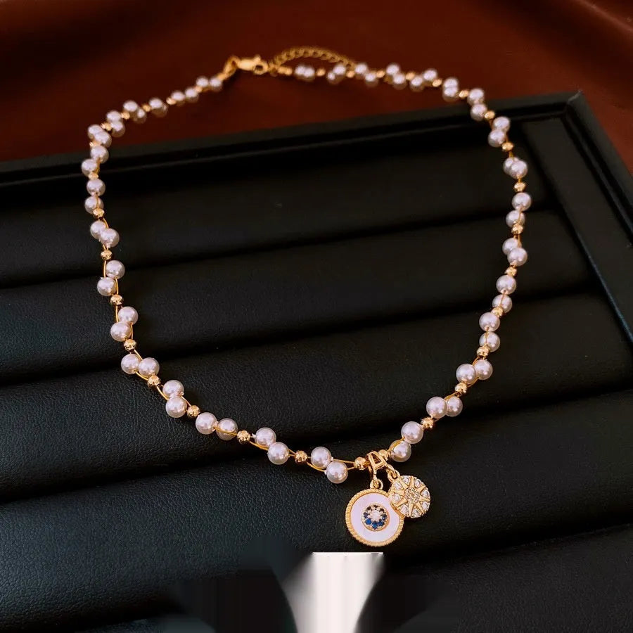 Gold electroplated round pendant necklace with zircon pearl on an adjustable clavicle chain.