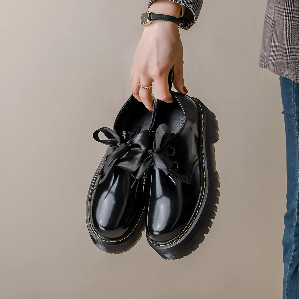 Women's black thick-soled leather shoes with cross strap design and lace-up closure
