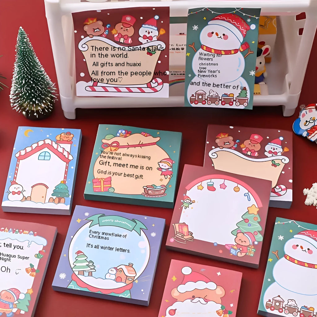 Christmas sticky notes book showing eight festive designs including elf, Santa, snowman, gift, house, bear, crystal ball, and sled