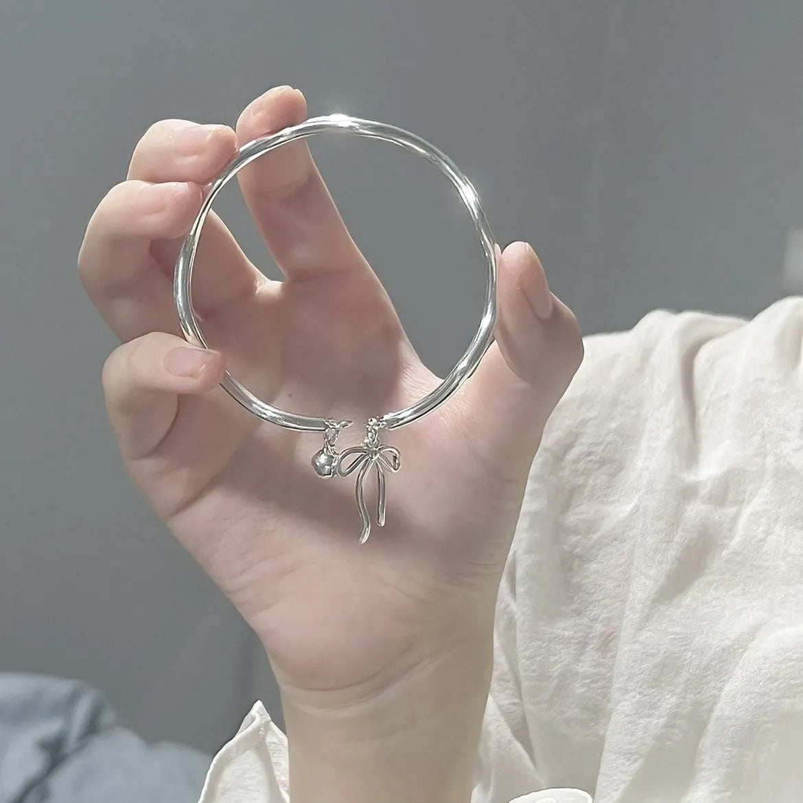 Silver adjustable bow bracelet with bowbell clasp on adjustable chain