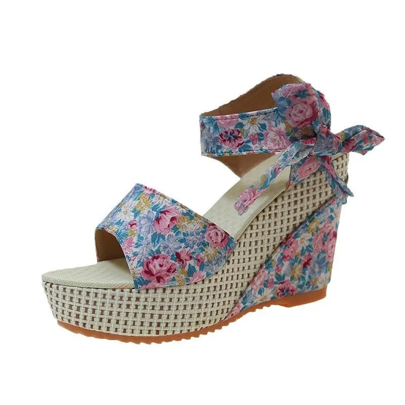 Women's wedge peep toe sandals with ankle-strap buckle, cloth upper, and rubber sole in a floral pattern.