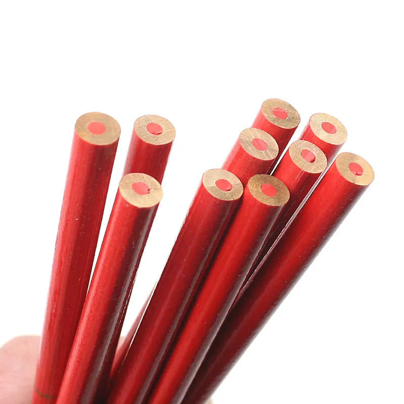 Ten red and blue round wooden carpenter pencils for marking, laid out on a work surface.