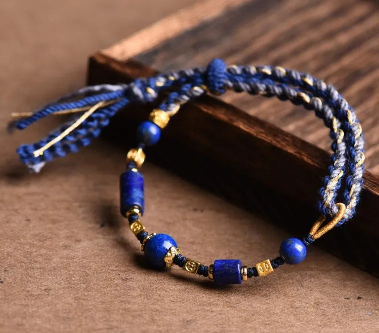 Hand-woven lapis lazuli flexible wire bracelet with simple ethnic design on white background