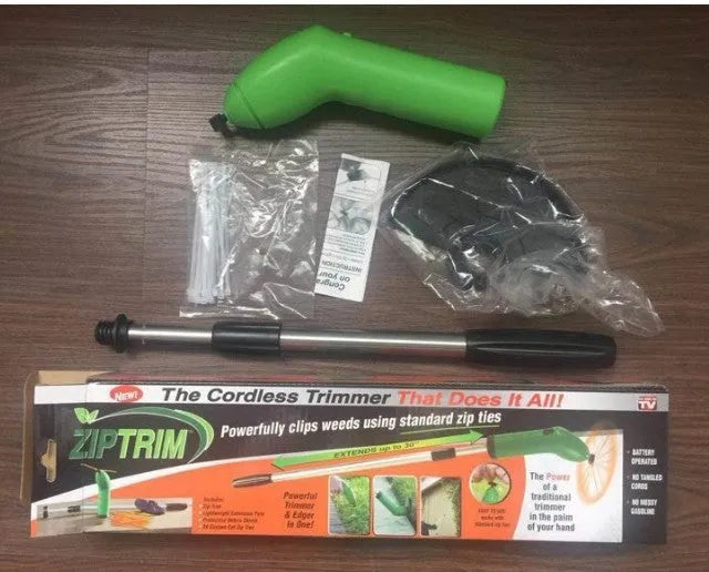 Cordless lawn trimmer with lightweight extension pole and protective debris shield on grass