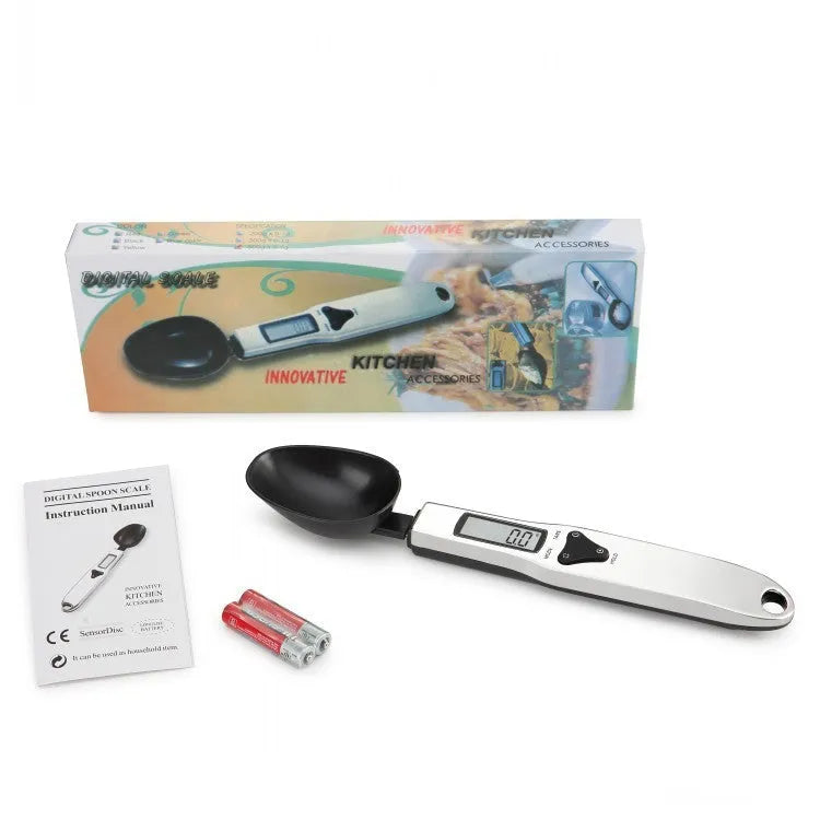 Digital smart measuring spoon with LCD display showing weight reading, on a kitchen countertop