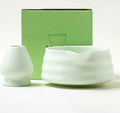 Ceramic matte tea whisk stand in Japanese style on a neutral background with a tea whisk placed upright inside the holder