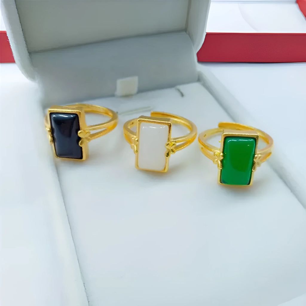Adjustable brass gold-plated ring with electroplated finish and a coloured gemstone.