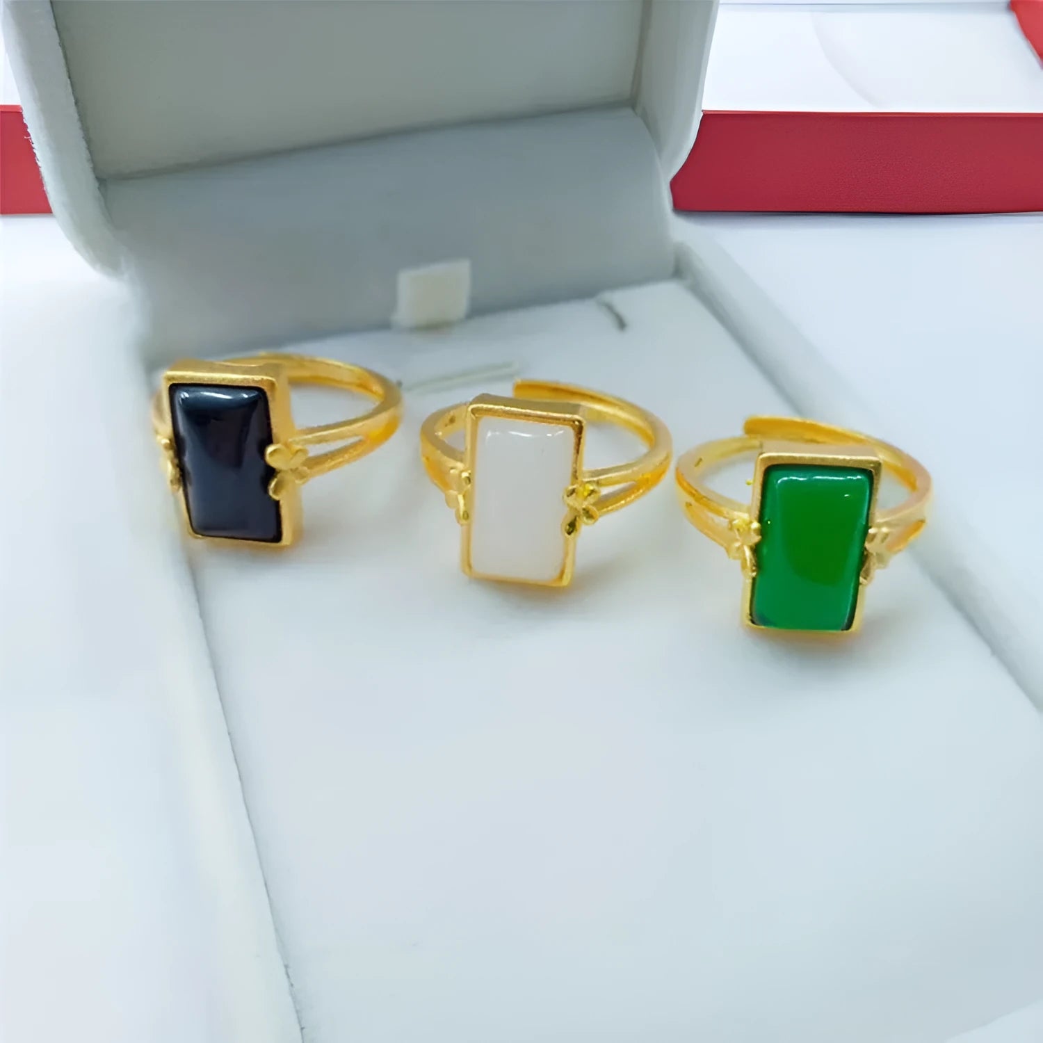 Adjustable brass gold-plated ring with electroplated finish and a coloured gemstone.