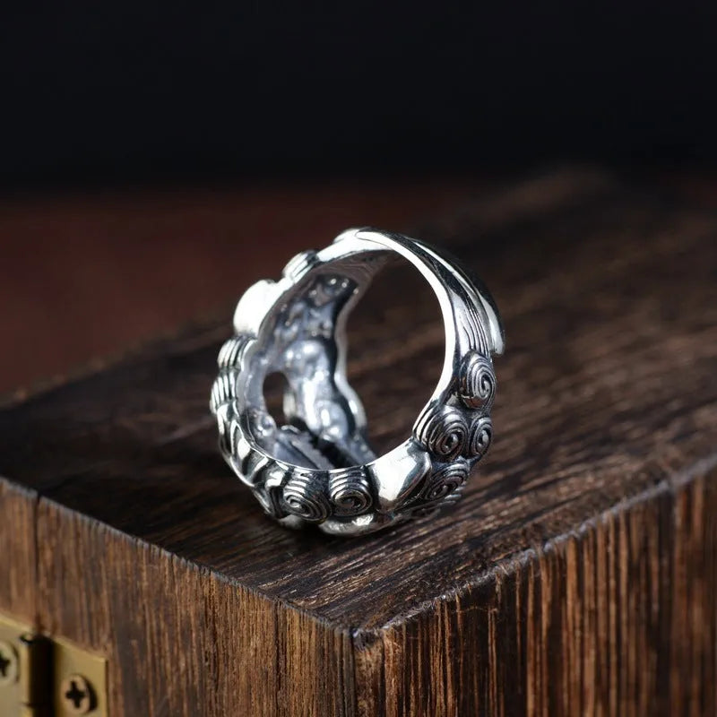 Silver open-style ring with detailed domineering jibeast animal pattern and diamond accents