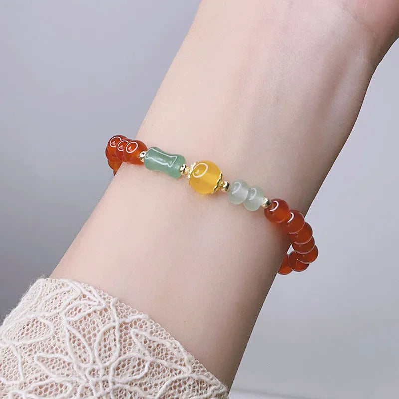 Handmade red agate bracelet with dragon motif and lucky charm beads.