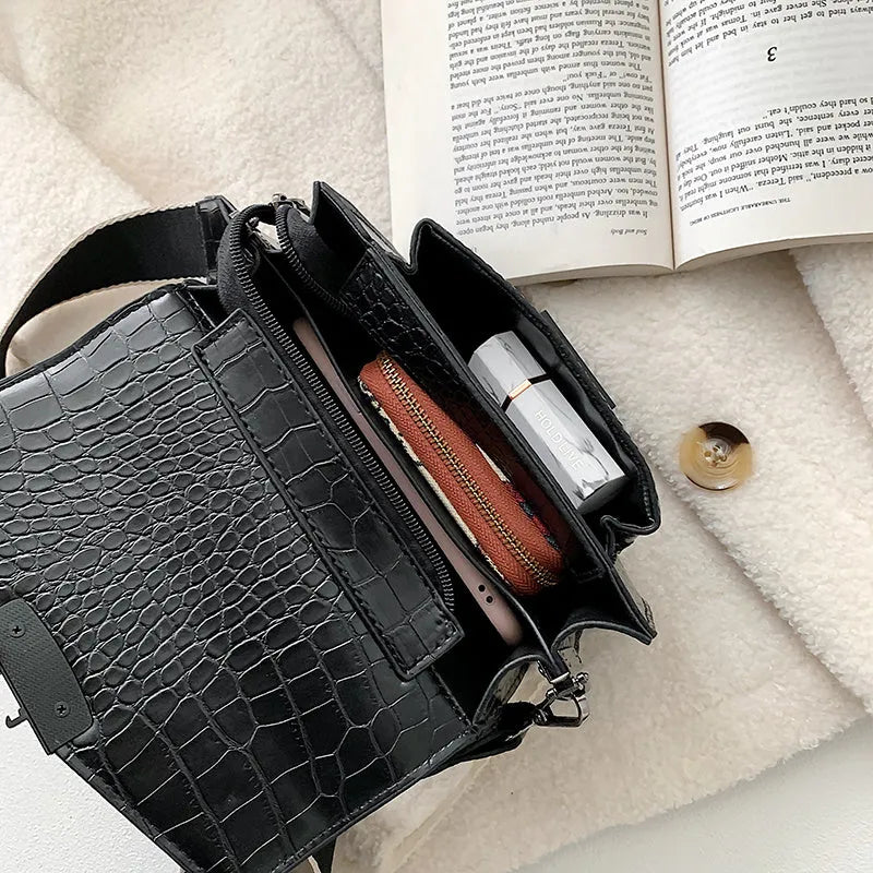 Vintage-style women's crossbody bag in PU leather, shown in black, with adjustable strap.