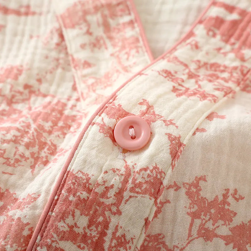 Women's pink cotton gauze lounge suit set with long sleeve top and trousers on a hanger.