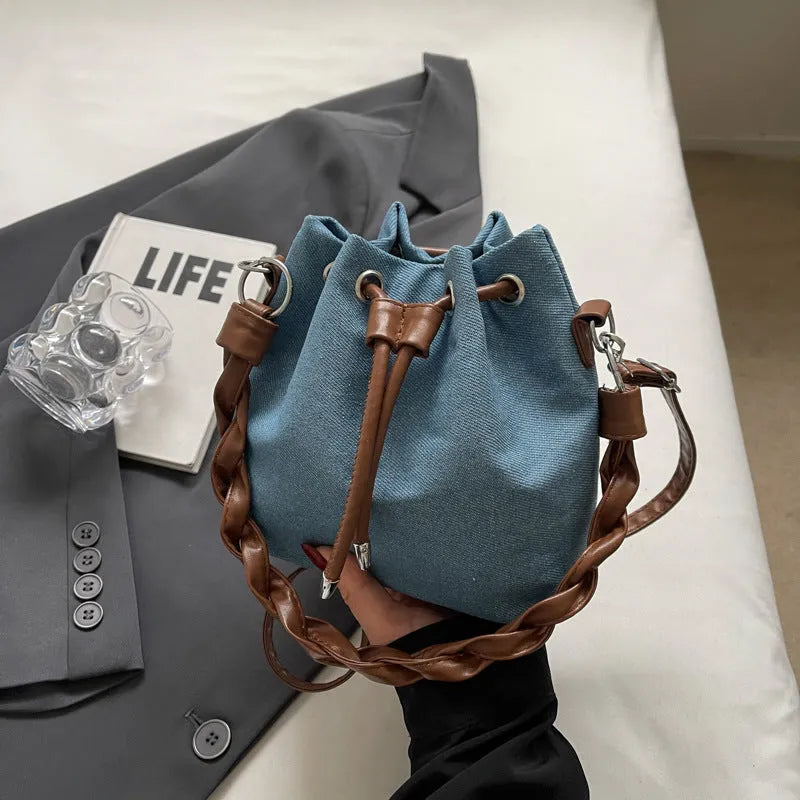 Blue synthetic leather cross body bucket bag with one-shoulder strap and sandwich pocket design