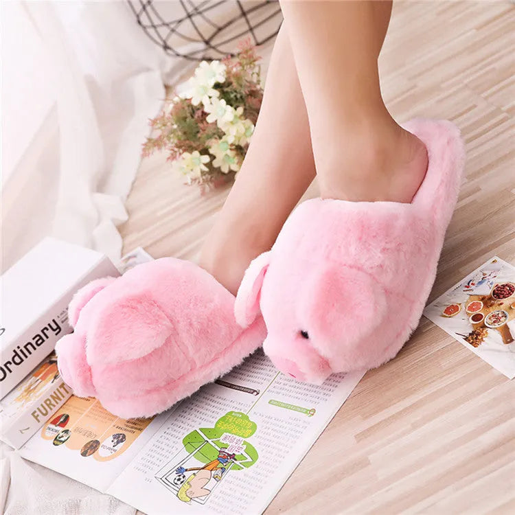 Pair of soft pink pig-shaped plush slippers with a cute animal face design.