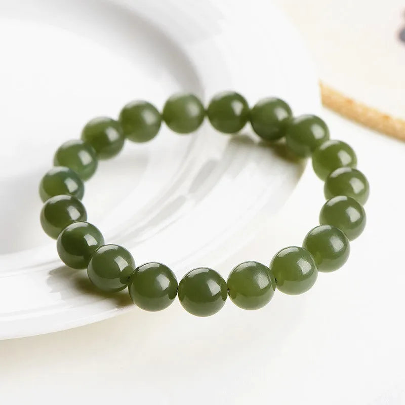 Polished Hetian jade bead bracelet in ice-clear colours on a wrist, showing spherical beads.