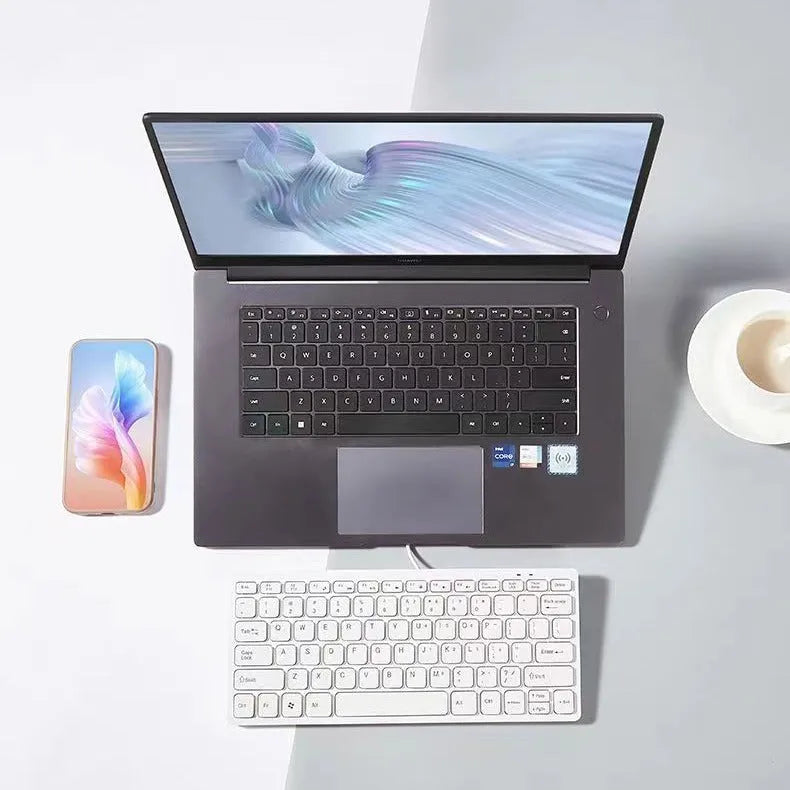 Compact wired USB mini keyboard in black, white, pink, or blue colours on a desk.