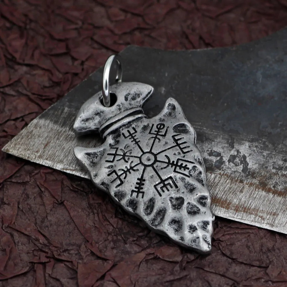 Alloy compass pendant necklace with twisted chain on a flat surface showing silver finish