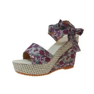 Women's wedge peep toe sandals with ankle-strap buckle, cloth upper, and rubber sole in a floral pattern.