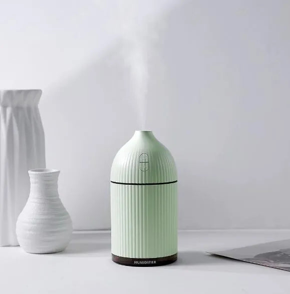 White ultrasonic aromatherapy diffuser with LED lights showing water mist emission