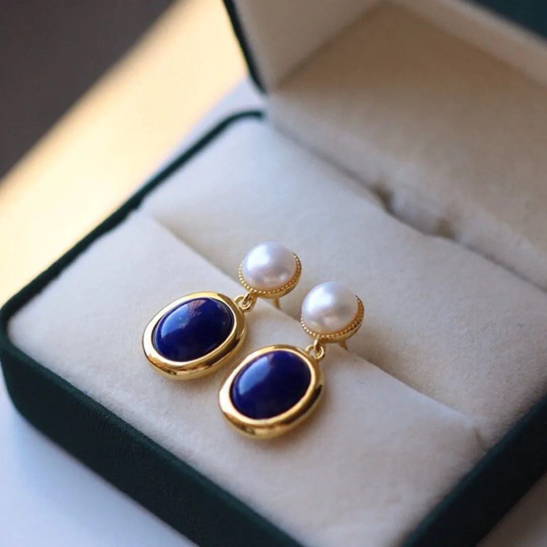 A pair of simple 925 silver earrings with blue lapis lazuli pearls and auspicious patterns.