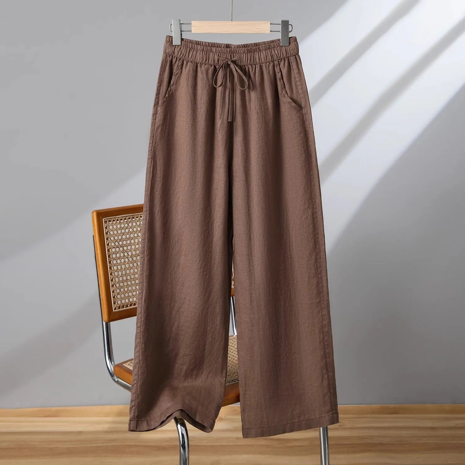 Women's apricot straight-leg casual trousers with a drawstring elastic waistband laid flat.
