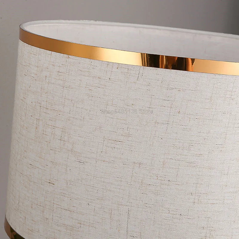 Simple bedroom table lamp with black iron body and cloth lampshade on a desk