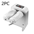 White automatic electric dumpling maker machine on a kitchen counter with USB cable and accessories
