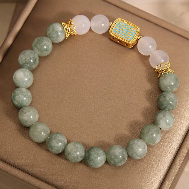 Women's oil green emerald crystal bracelet with five scripture pieces on a wrist.
