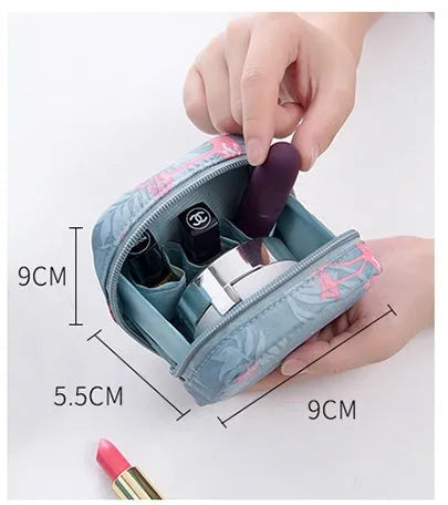 A blue cloth cube-shaped makeup storage bag sitting upright, showing its plain fabric design.
