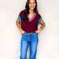 Burgundy women's loose V-neck sweater with contrast trim on cuffed short sleeves