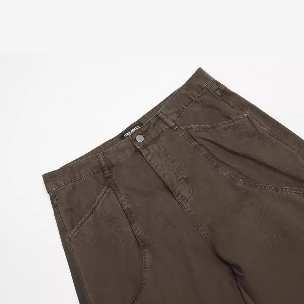 Men's brown straight-leg cotton trousers showing high-waist design with wide leg opening and zipper fly