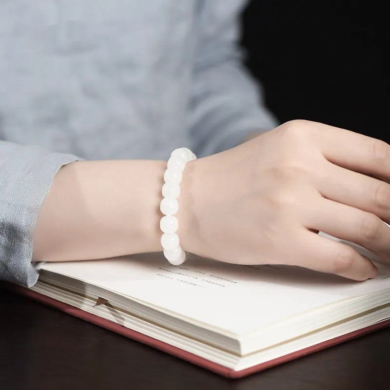 White Hetian jade barrel bead bracelet on a wrist, showing three bead size options for men and women.