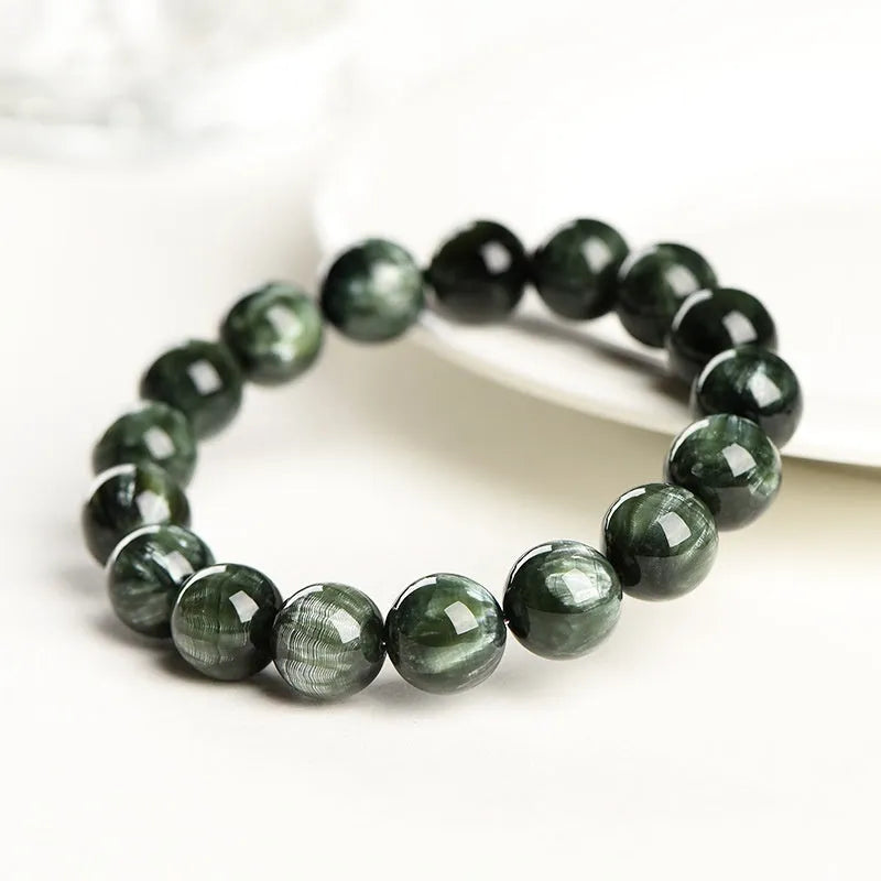 Natural green dragon crystal round bead bracelet with ruyi design on a wrist.