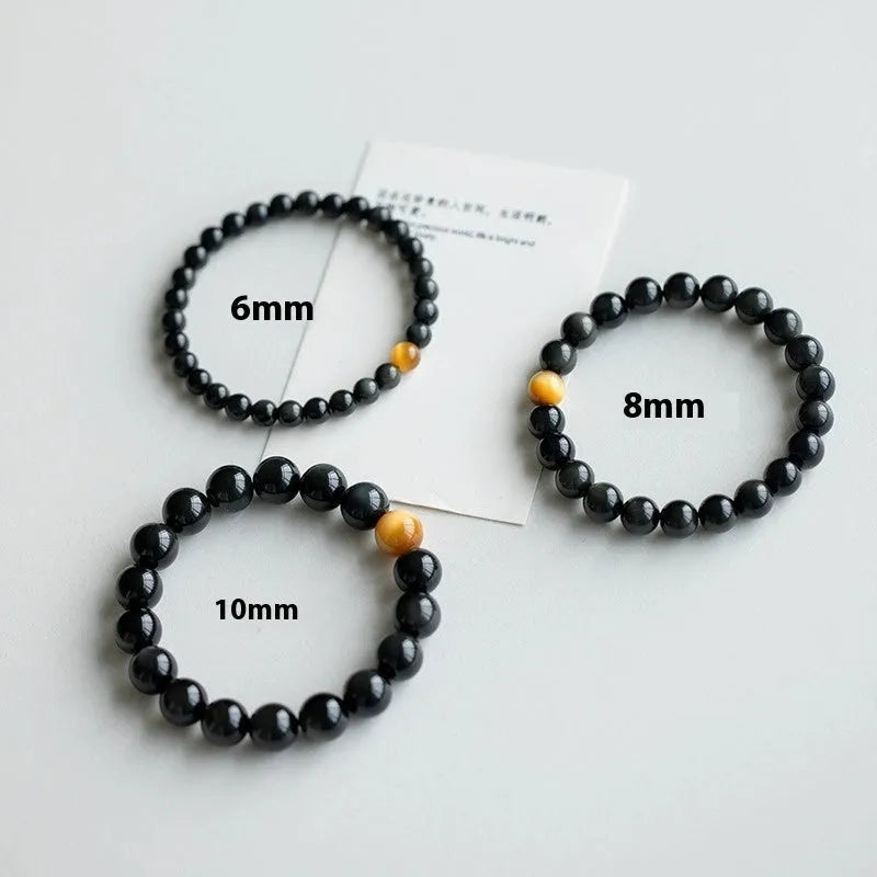 Natural black obsidian bracelet with geometric beads in 10mm size on neutral background